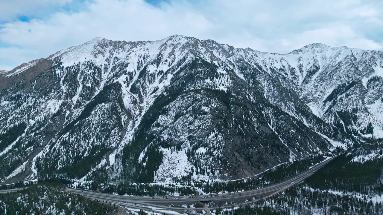 Crinale montuoso aspro di Frisco Gulch con pendii coperti di neve e valli boscose, panoramica aerea con drone