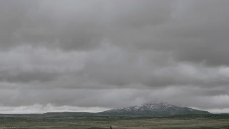 Clouds-pass-over-a-mountain-on-a-grassy-plain