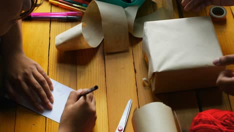 High-angle-view-of-young-asian-couple-packing-gift-box-in-living-room-at-home-4k