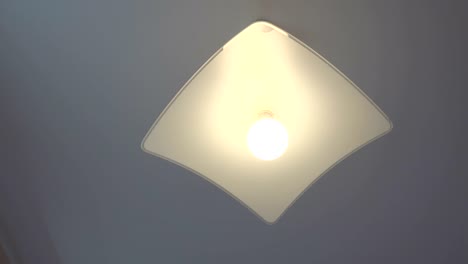 close-up of led light in home ceiling turning on and off.