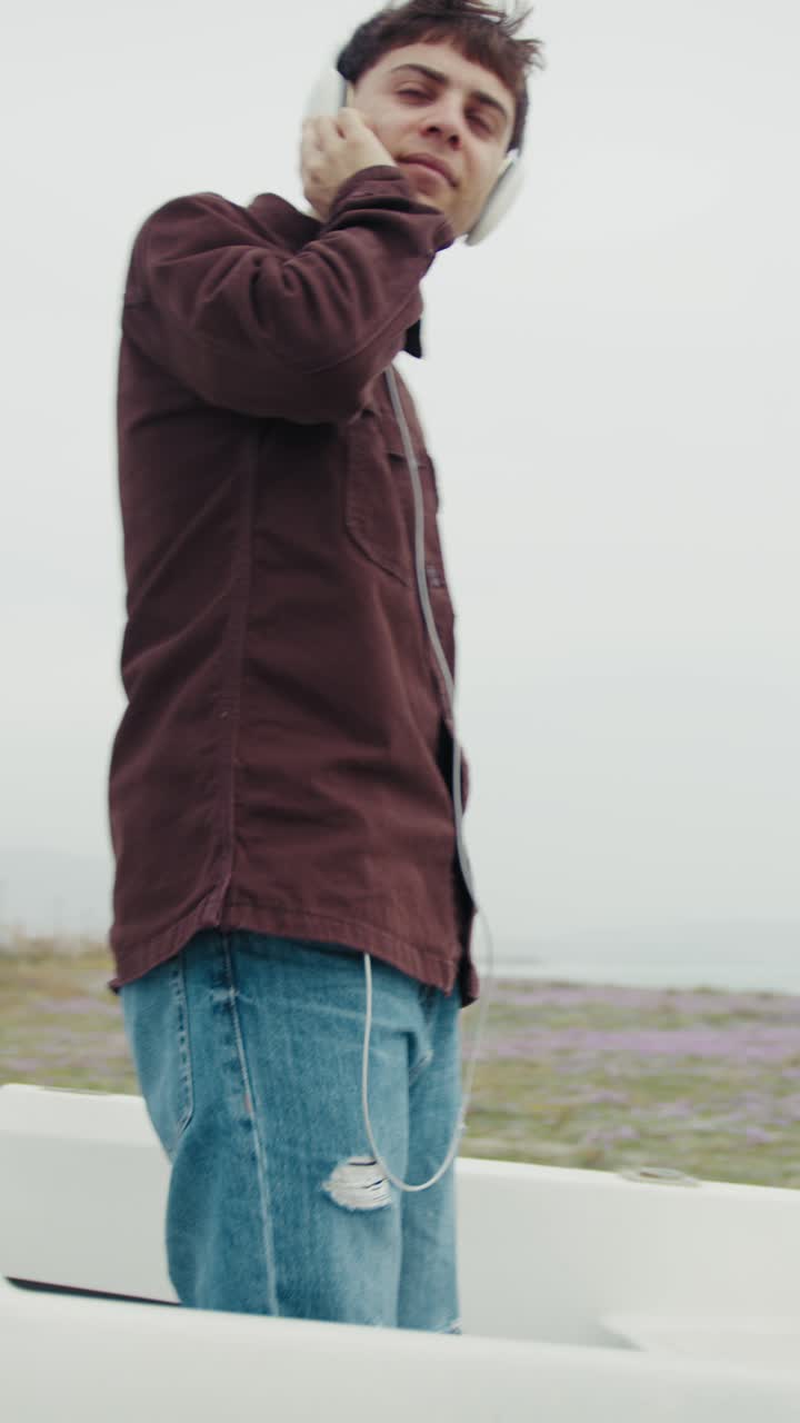 Man Dancing To The Music Inside A Boat On The Beach During Winter