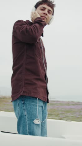 man dancing to the music inside a boat on the beach during winter