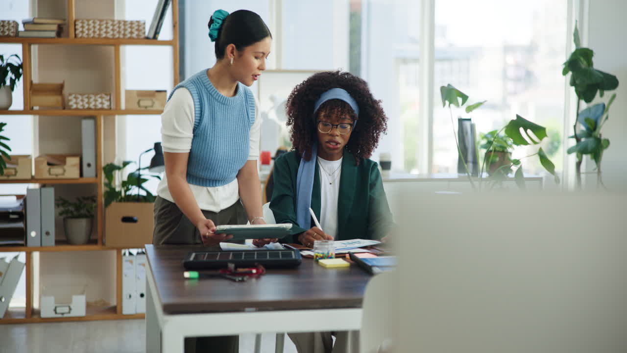 Two Diverse Businesswomen Collaborating on Project in Modern Office