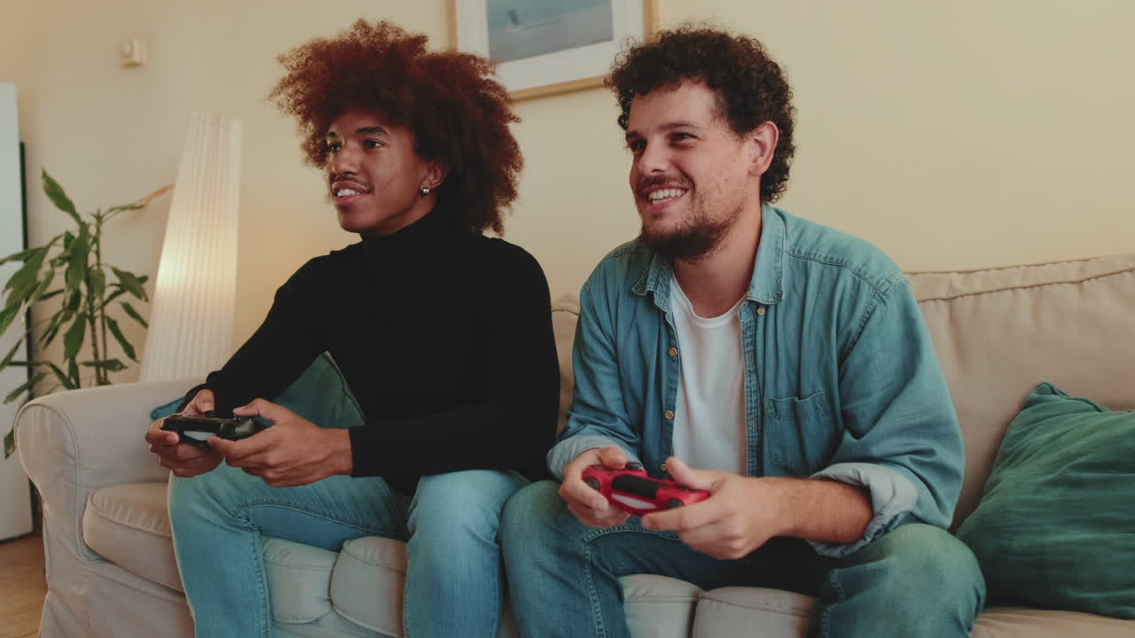 Due uomini giocano ai videogiochi su un divano