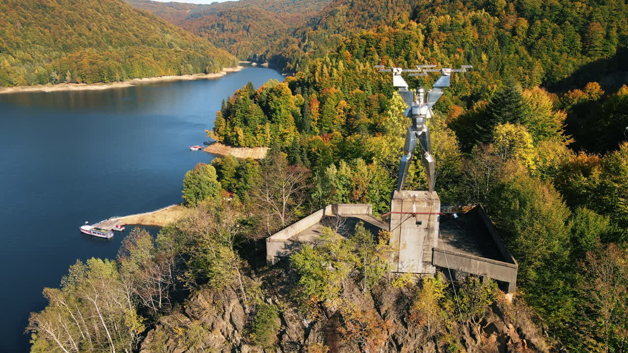 Aerial view of Vidraru Lake and statue in Romania
