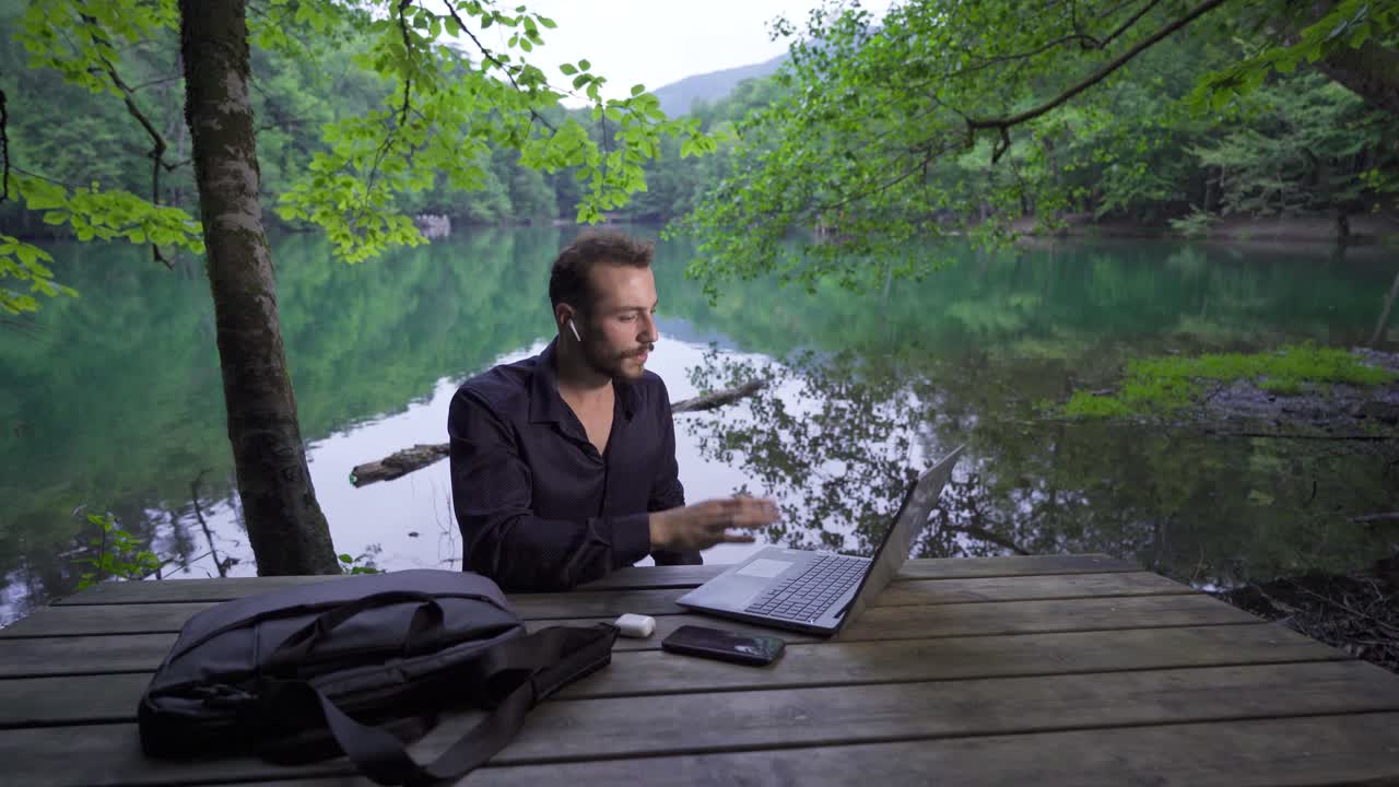 hombre de negocios trabajando con su computadora portátil en el bosque.