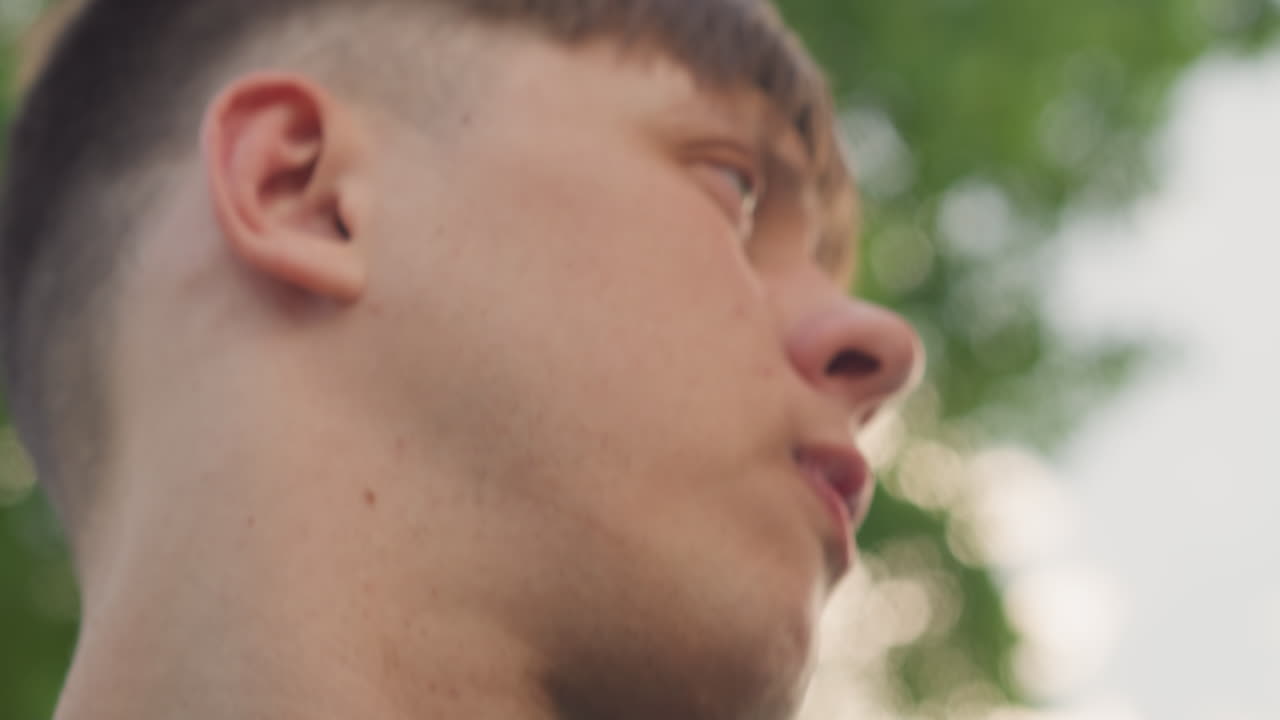 10대 청소년이 환경을 조사하고, 젊은 개인은 조용히 주변을 관찰하며, 젊은이는 주변 공원 지역을 주의 깊게 살펴보고, 후드티를 입은 10대가 조심스럽게 주변을 둘러봅니다.