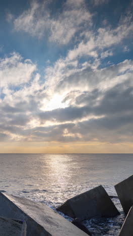 barcelona sea at sunrise from rocks and concrete blocks in vertical