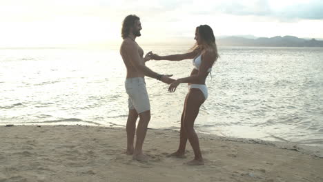 couple dancing on a beach at sunset