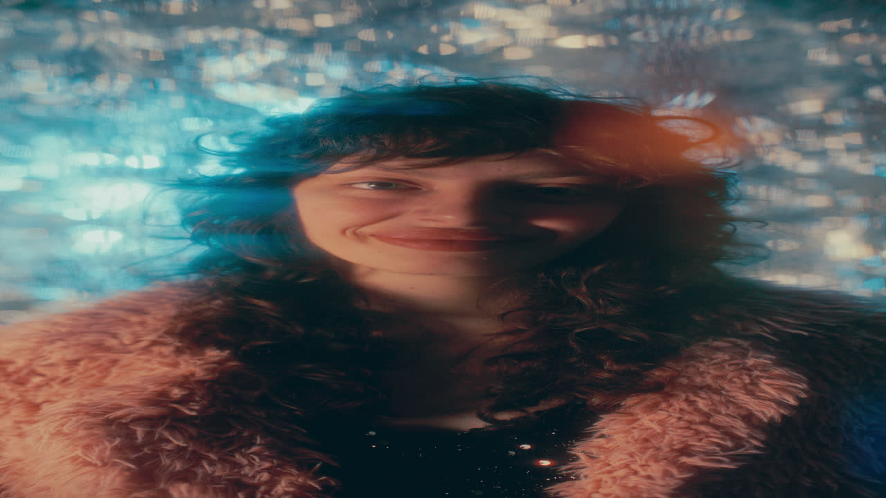 Portrait of Smiling Woman in Fur Jacket Surrounded by Glowing Bokeh Lights
