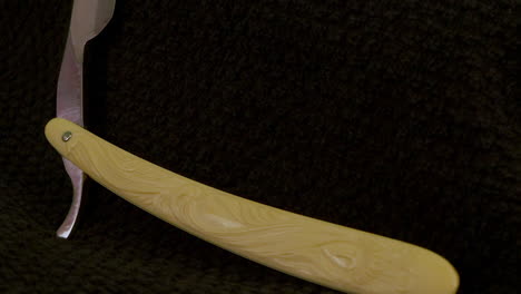 afeitadora recta antigua con mango de marfil tallado gira en estudio negro