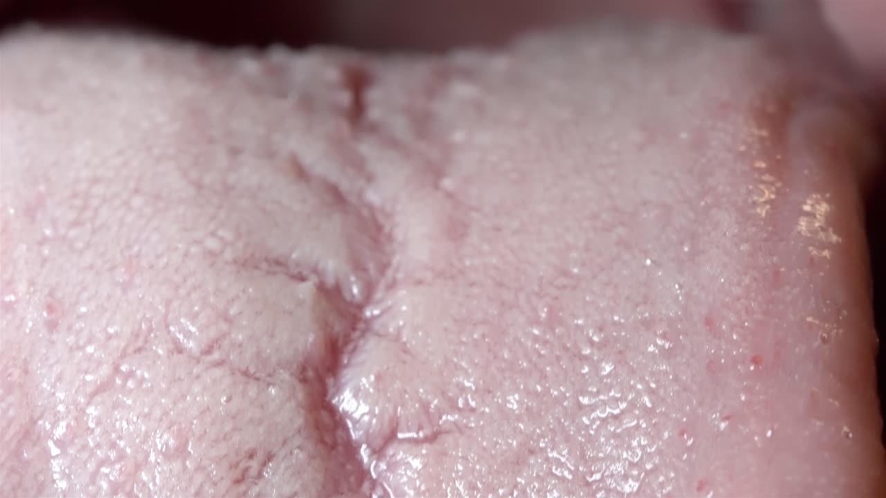 A detailed close-up of a tongue, showcasing its texture and intricate surface features.