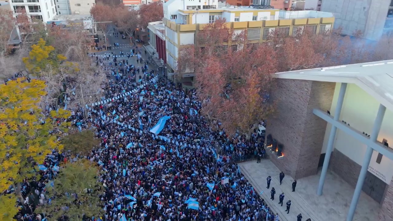 Plaza 25 de Mayo a San Juan che mostra grandi folle che sventolano bandiere per celebrare il risultato dell'Argentina ai Mondiali. Planata aerea ad alta quota nel pomeriggio
