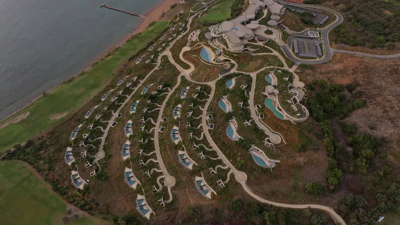 Vista aérea de luxuoso resort e campos de golfe à beira-mar azul em Pylos.