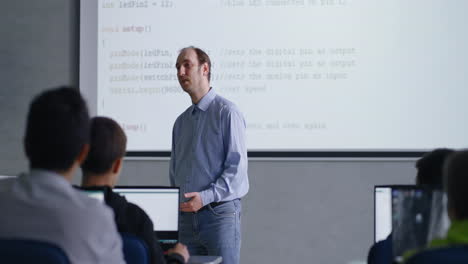 teacher lecturing students on programming in a classroom