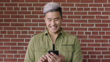 portrait of young asian man using smartphone smiling texting browsing social media