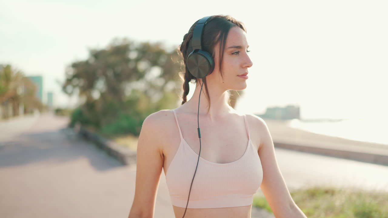 야외에서 헤드폰을 들고 있는 여자