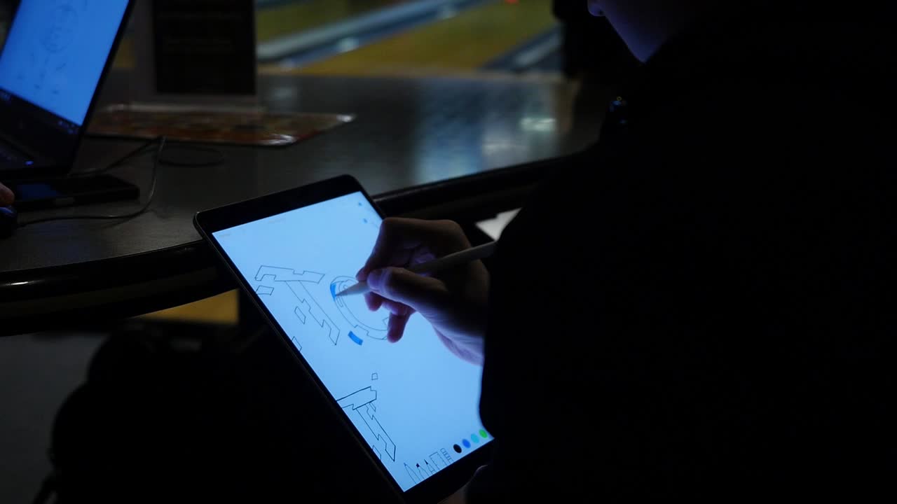 Person Drawing on Tablet in a Bowling Alley