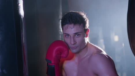 Starker-Männlicher-Boxer-Schlägt-Beim-Training-Auf-Den-Boxsack