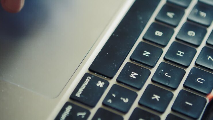Fingers using touchpad on mac computer with dirt on the keyboard, close up