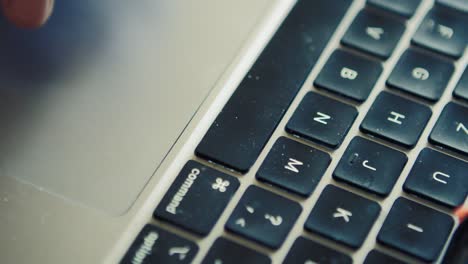 Fingers-using-touchpad-on-mac-computer-with-dirt-on-the-keyboard,-close-up