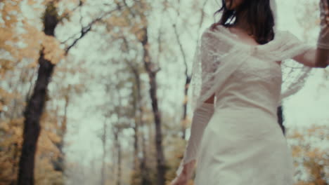a mysterious woman in a white dress with a lantern in an autumn forest