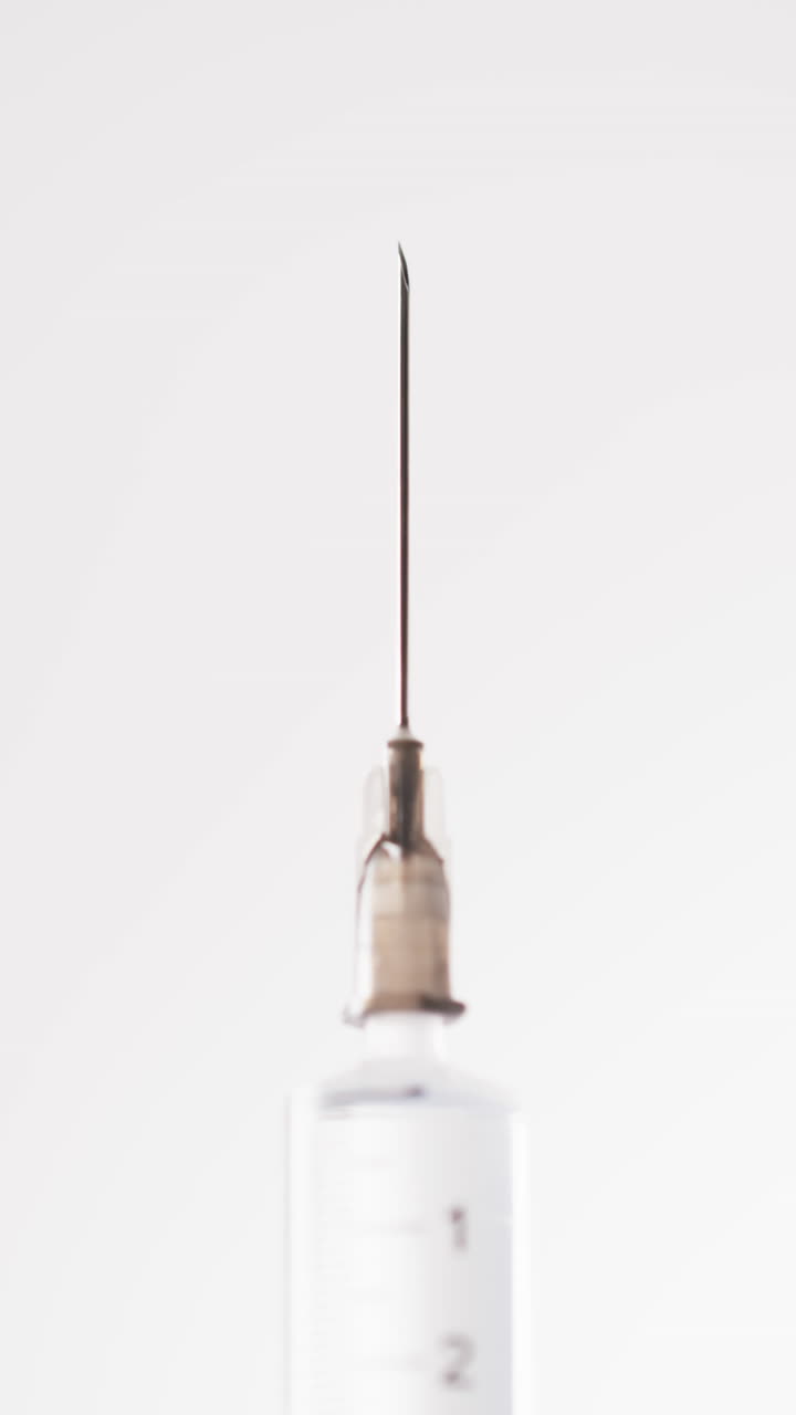 Vertical video of laboratory syringe with copy space on white background