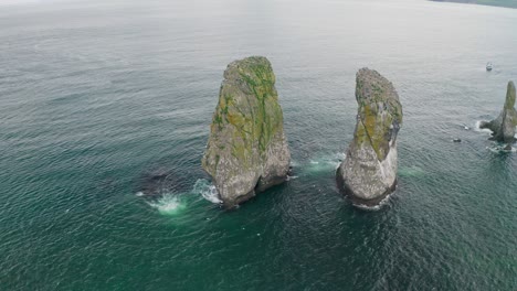 circle sea panorama. huge cliffs towering in teal water, seagulls flying around