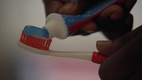 applying toothpaste  on toothbrush bathroom