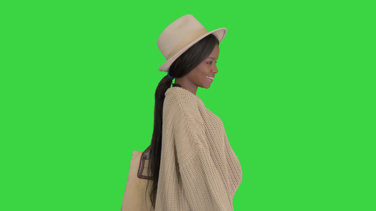 Fashionable african american woman posing in knitwear and white hat on a Green Screen, Chroma Key