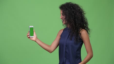 young beautiful hispanic businesswoman showing phone