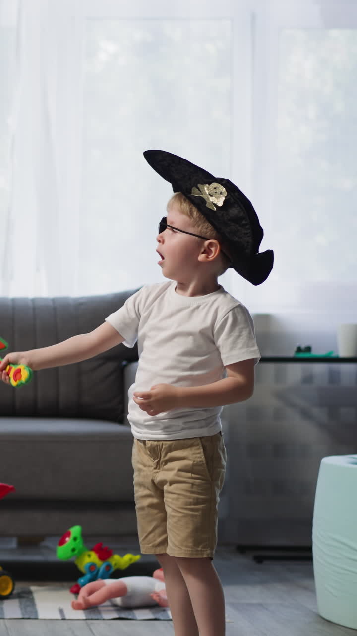 niño en edad preescolar y niño pequeño juegan a duelo con espadas de juguete activamente en la acogedora sala de estar. niño alegre con sombrero y parche para los ojos y niña con trenzas largas juegan piratas