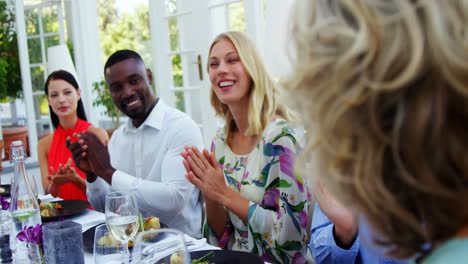 amigos aplaudiendo a la mujer mientras comen