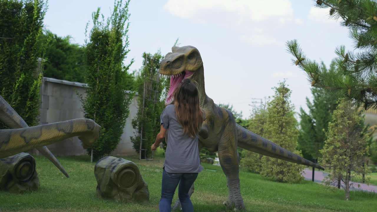 la mujer en el parque de dinosaurios temerosa del dinosaurio modelo
