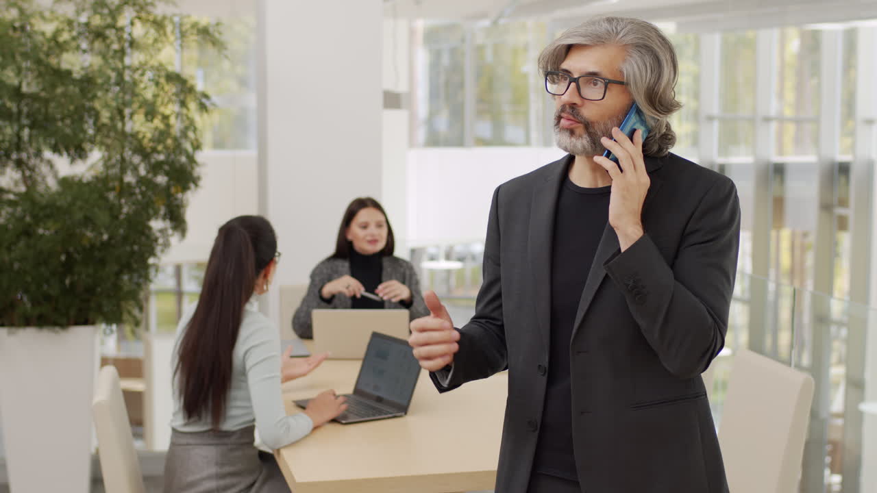Uomo d'affari che parla al telefono durante una riunione.