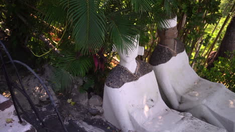 ancient asian statues in a tropical climate - concept: historic, spirituality, tranquil, religious, faith, peace