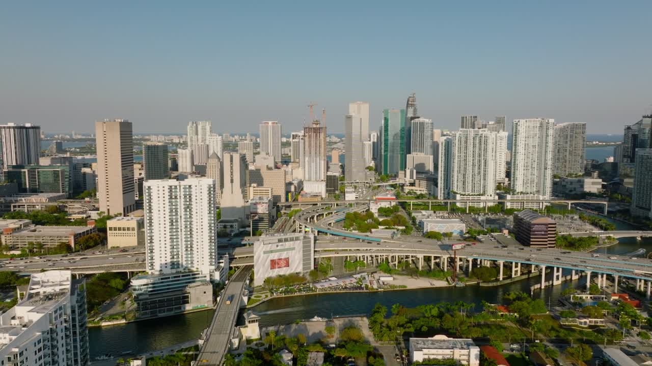 포워드는 도시 위를 날아갑니다. 현대적인 럭셔리 도시 구역의 고층 아파트 건물, 바쁜 다차선 고속도로 교차로. 마이애미, 미국