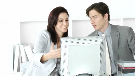 two attractive businesspeople working at a computer