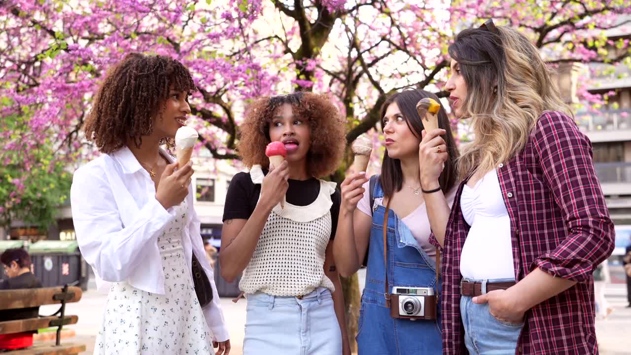 Four friends eating ice cream in a park