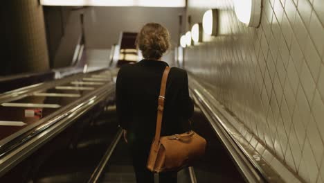 Junge-Geschäftsfrau-Auf-Der-Rolltreppe-In-Der-U-Bahn-Station,-Die-Zur-Arbeit-Pendelt