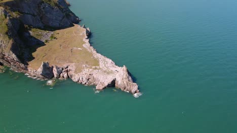 Toma-Aérea-En-Círculos-Del-Promontorio-Costero-Llamado-Punto-De-Cantera-Larga-En-Torquay,-Devon,-Inglaterra