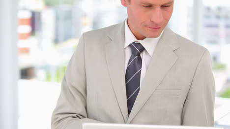 Business-man-smiling-and-using-his-laptop