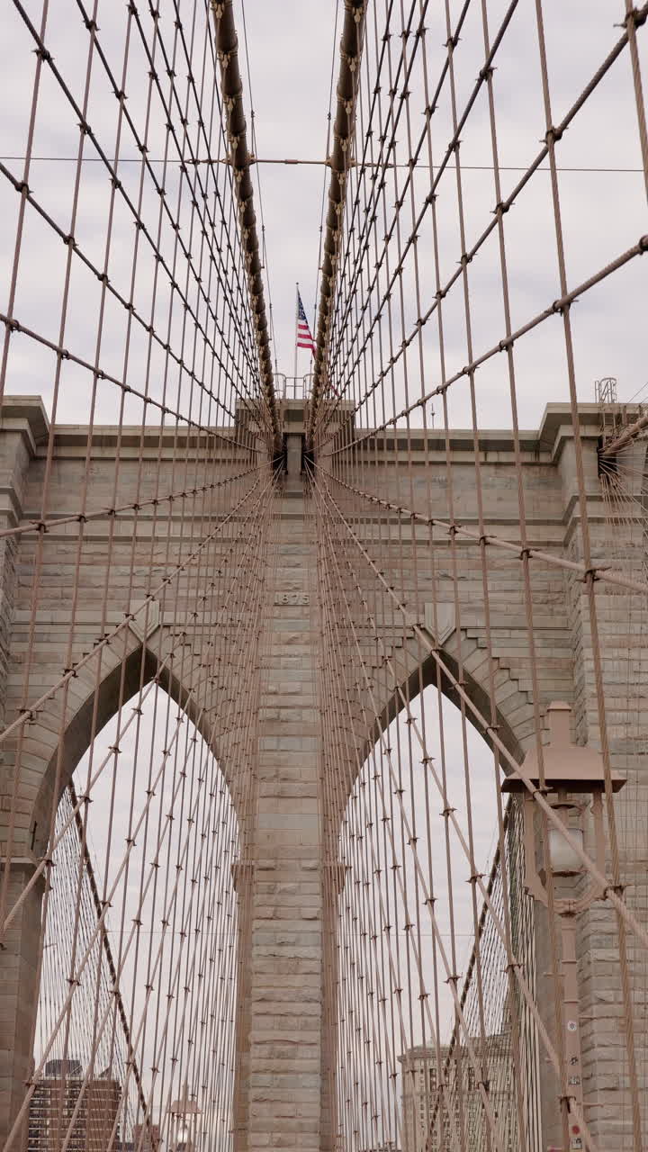 Torre del Ponte di Brooklyn con bandiera americana a New York City.