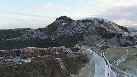 Toma-Aérea-De-Los-Riscos-De-Salisbury-En-Arthurs-Seat-En-Edimburgo-En-Una-Mañana-Nevada