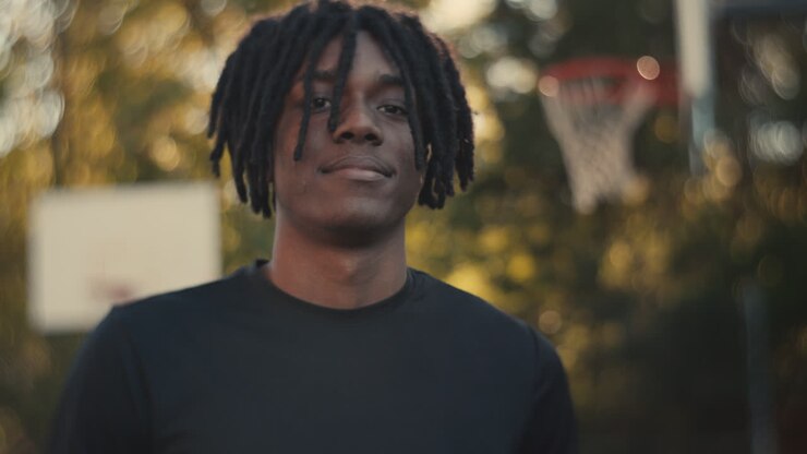 Man with dreadlocks at a basketball court