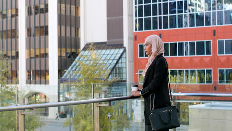 Vista-Lateral-De-Una-Joven-Asiática-Con-Hijab-Parada-En-La-Ciudad-4k