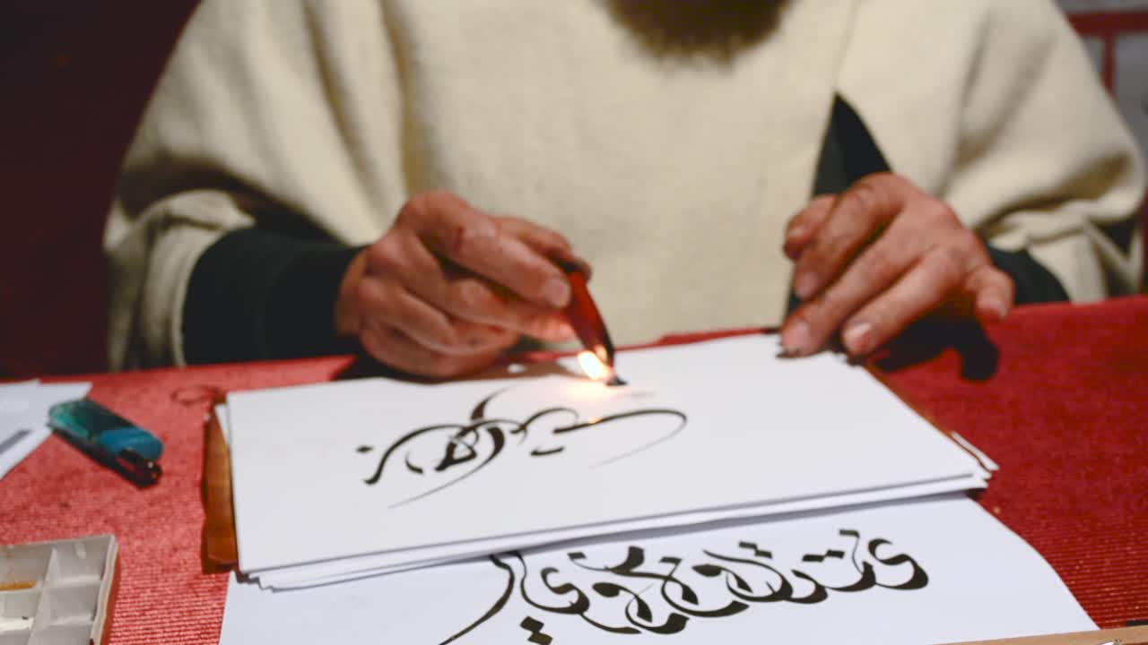 A men drwaing calligraphy in Arabic