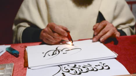 a men drwaing calligraphy in arabic