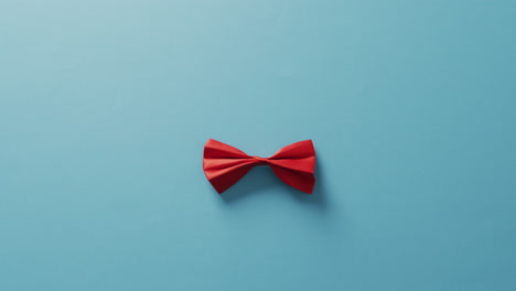 video of red bow tie lying on blue background