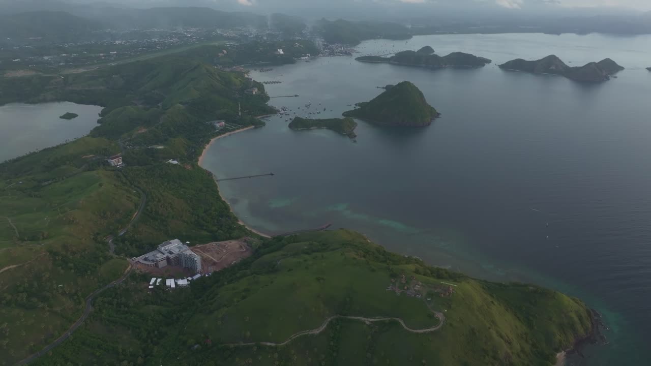 Engebeli Komodo kıyı şeridinde gün batımı parıltısı, Labuan Bajo, Endonezya